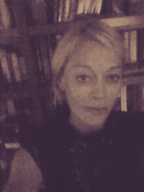Author Irena Phaedra in front of bookshelf, 2026